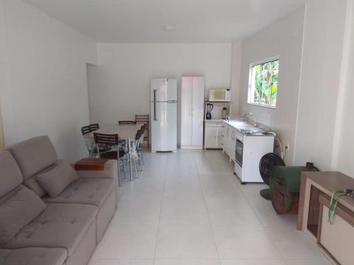 ein Wohnzimmer mit einem Sofa und einem Tisch sowie eine Küche in der Unterkunft Paraíso em Balneário Camboriú in Balneário Camboriú