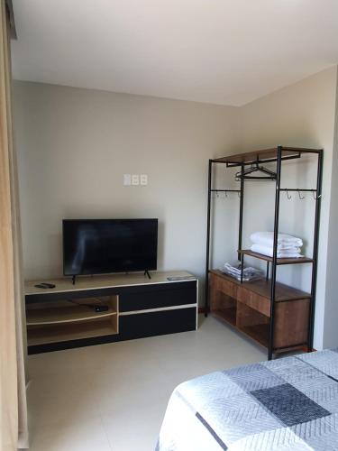 1 dormitorio con TV de pantalla plana y 1 cama en Rota da Praia II, en Barra Grande