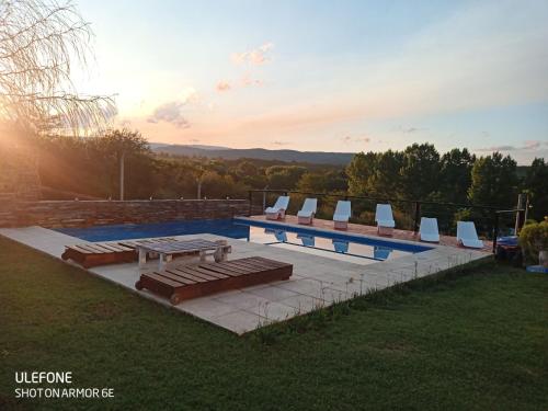 una piscina con tumbonas y una mesa en MIracampo, en San Antonio de Arredondo