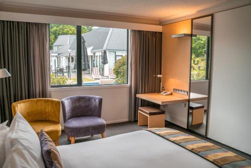 a hotel room with a bed and a desk and a window at Scenic Hotel Marlborough in Blenheim