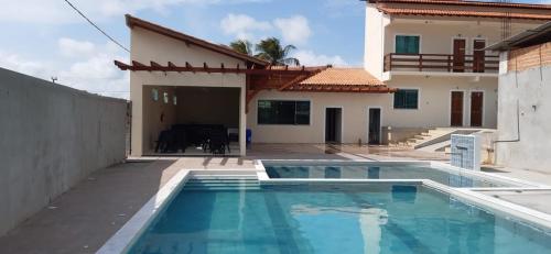 a swimming pool in front of a house at Hotel Brio in Salinópolis
