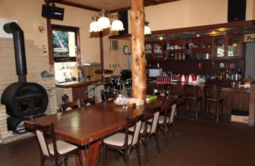 een restaurant met een houten tafel en een open haard bij Guesthouse UNILA in Hakusan