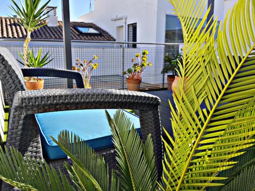stół rattanowy i krzesła na patio z roślinami w obiekcie Javi s Home Trinidad w Maladze