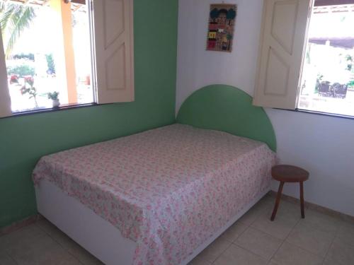 a small bedroom with a bed and two windows at Casa de praia condomínio fechado, frente para o mar in Estância