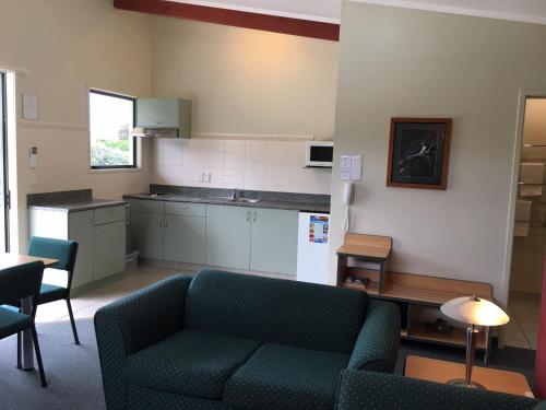 a living room with a couch and a kitchen at Bay of Islands Gateway Motel & Apartments in Paihia
