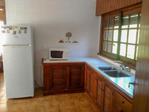 a kitchen with a white refrigerator and a sink at Cabaña Ostende in Ostende