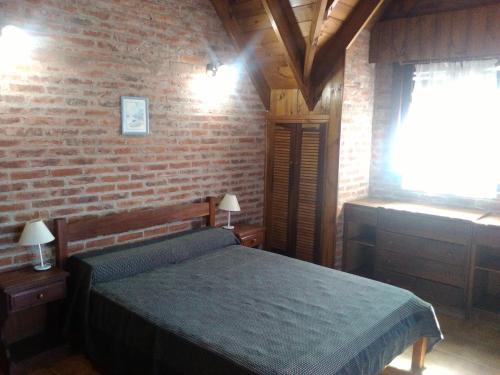 a bedroom with a bed and a brick wall at Cabaña Ostende in Ostende