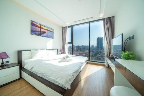 a bedroom with a large bed and a large window at Vinhomes Metropolis Hanoi - CitiHome in Hanoi