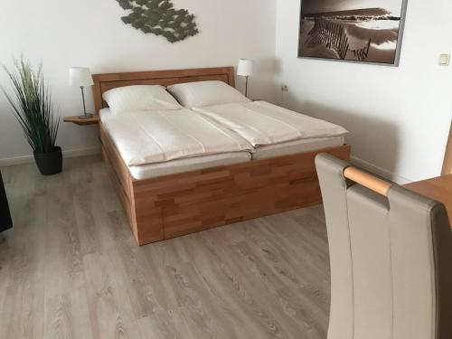 um quarto com uma cama de madeira em Steiner Strandappartements Appartement 307 Süd- Landseite em Stein