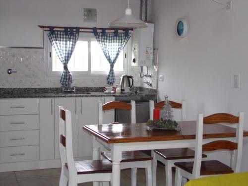 a kitchen with a table and chairs and a window at Alma Cabaña de Mar in San Eduardo del Mar