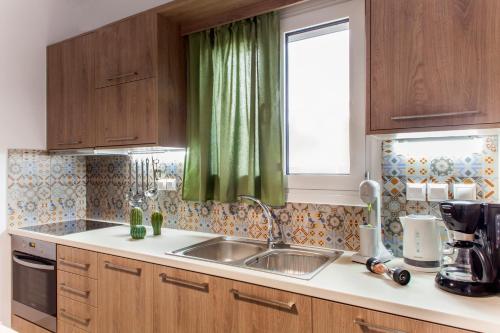 a kitchen with a sink and a green curtain at Konstantinos Villa in Koutsourás