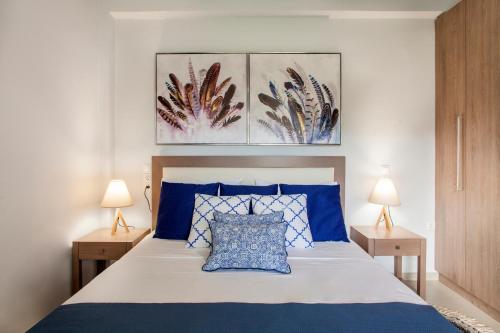 a bedroom with a blue and white bed with two lamps at Konstantinos Villa in Koutsourás