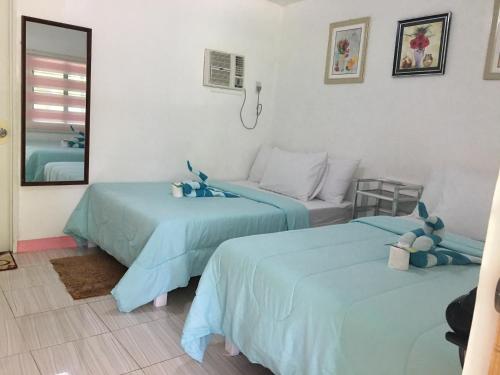 馬拉帕斯卡島的住宿－馬布海思雷舍潛水度假酒店，配有蓝色床单的客房内的两张床