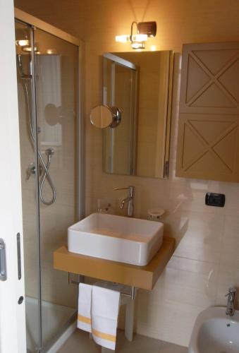 a bathroom with a white sink and a shower at Hotel Giglio in Salsomaggiore Terme