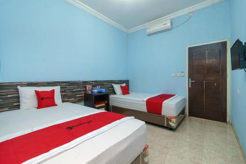 RedDoorz Syariah @ Mora Garden Bungo tesisinde bir odada yatak veya yataklar