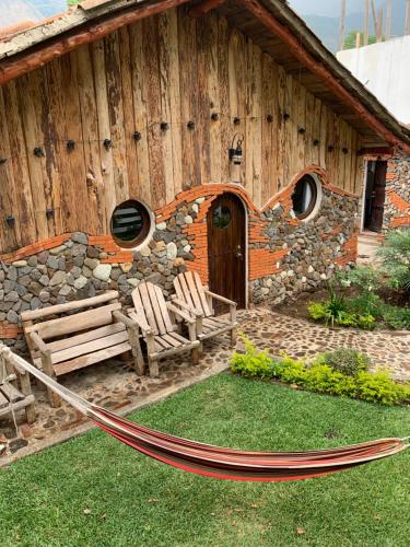 a building with a hammock in front of it at Cabañas de Tzununa in Tzununá