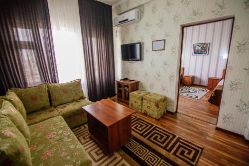 a living room with a couch and a table at Hotel Osh-Nuru in Osh