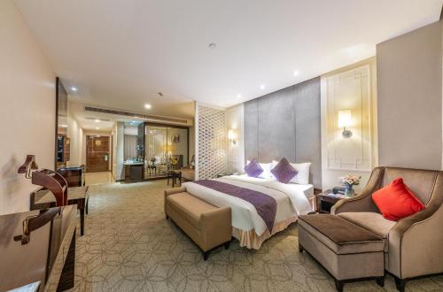 um quarto de hotel com uma cama e uma cadeira em Dorsett Wuhan em Wuhan