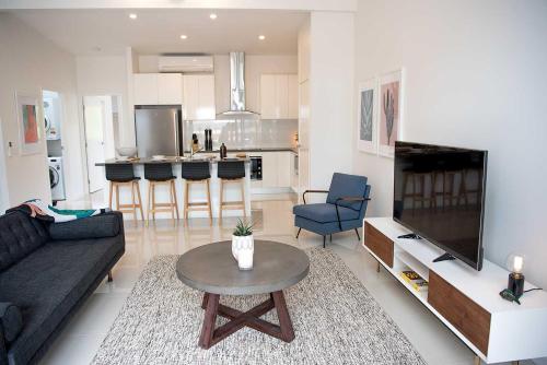 a living room with a couch and a table at Acacia Villa in Noosa Heads