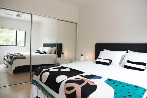 Acacia Villa في نوسا هيدز: غرفة نوم بها سريرين ومرآة