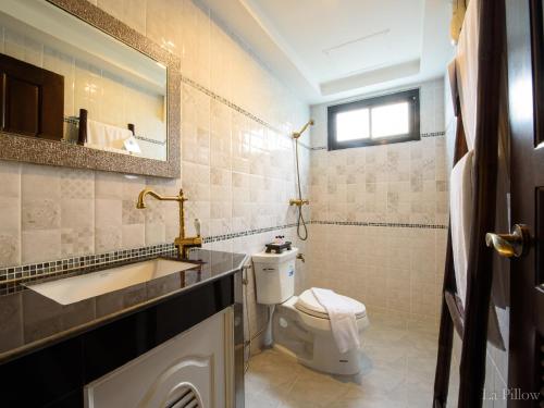 La salle de bains est pourvue de toilettes, d'un lavabo et d'un miroir. dans l'établissement La Pillow 8, à Chiang Mai