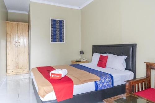 ein Schlafzimmer mit einem Bett und einem Kasten darauf in der Unterkunft RedDoorz Plus near Tambun Station in Bekasi