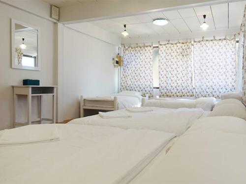 Habitación blanca con 2 camas y espejo. en Baan Pun Sook Resort, en Chao Lao Beach