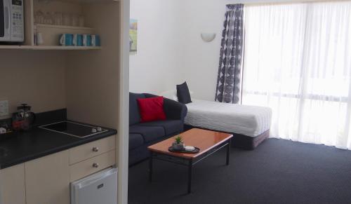 a small living room with a couch and a bed at Totara Lodge in Upper Hutt