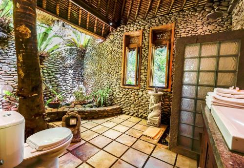 a bathroom with a toilet and a sink at Villa Beji Indah in Ubud