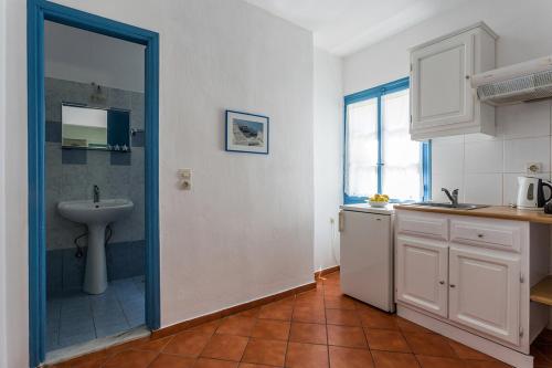 a bathroom with a sink and a shower in a kitchen at Limnonari Studio in Skopelos Town