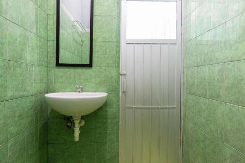 uma casa de banho com um lavatório e um espelho em SPOT ON 2063 Bethania Residence em Kupang