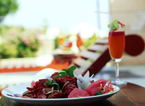a plate of food on a table with a drink at Clarks Safari Ranthambore in Khilchipur