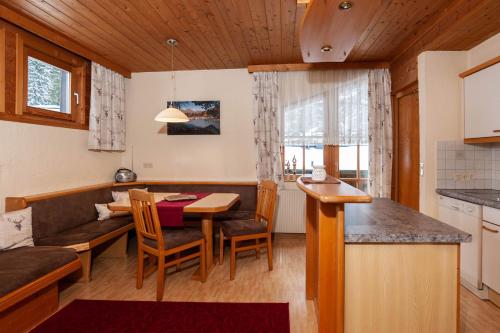 eine Küche und ein Wohnzimmer mit einem Tisch und einem Sofa in der Unterkunft Chalet Paznaun in Kappl