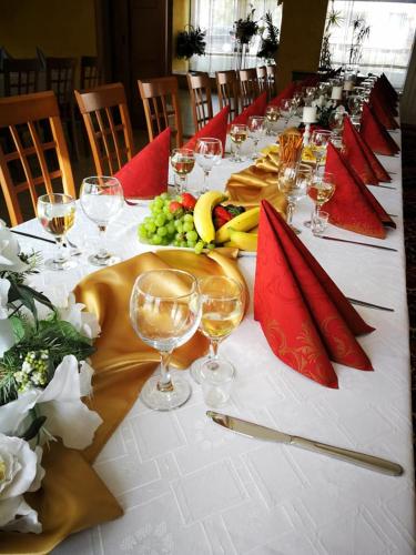 a long table with wine glasses and fruit on it at Hotel Mladosť in Lipany