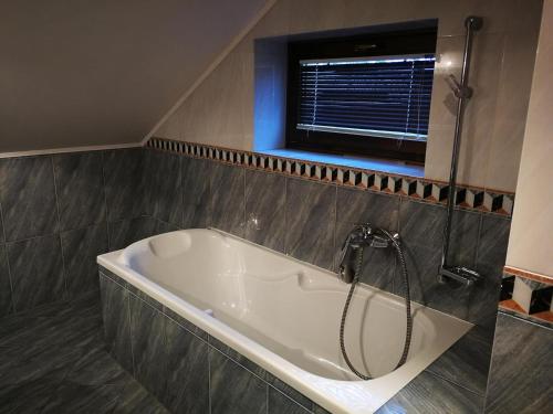 a bath tub in a bathroom with a window at Hotel Mladosť in Lipany
