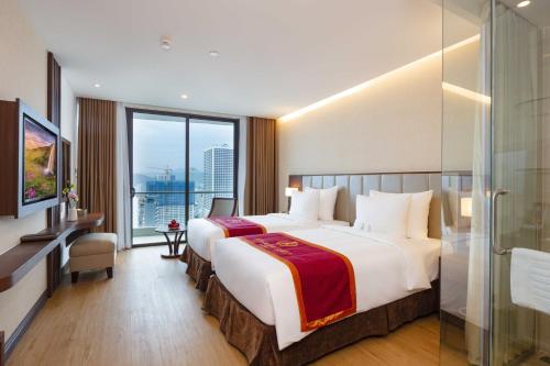 a hotel room with two beds and a large window at Regalia Gold Hotel in Nha Trang