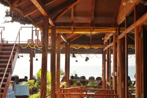 阿貢達的住宿－Agonda Sun Set，一群人坐在餐厅里,看着大海