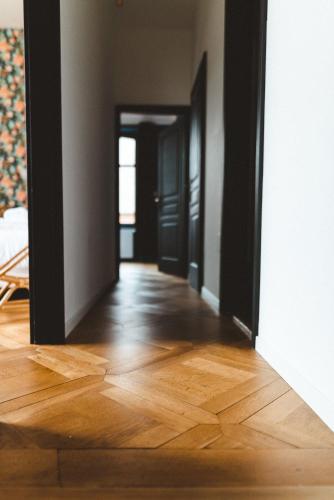 an empty room with a wooden floor and an open door at Sojolidays - Appartements d'hôtes sur la Route des Vins d'Alsace in Rorschwihr