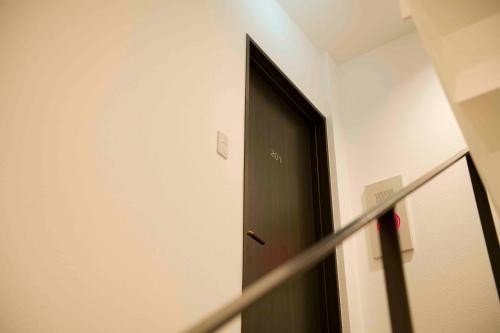 a black door in a room with a staircase at Shinjuku Miyabi Residence in Tokyo