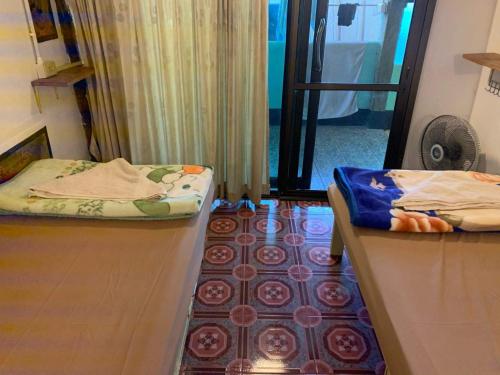 a room with two beds and a rug on the floor at Good Life Dacha Wellness Homestay in Pai
