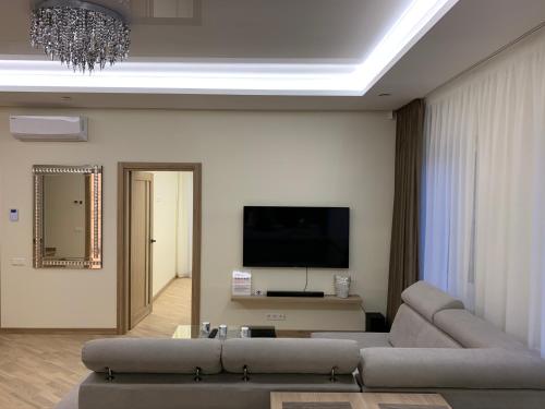 a living room with a couch and a flat screen tv at Roof terrace apartment in Panevėžys