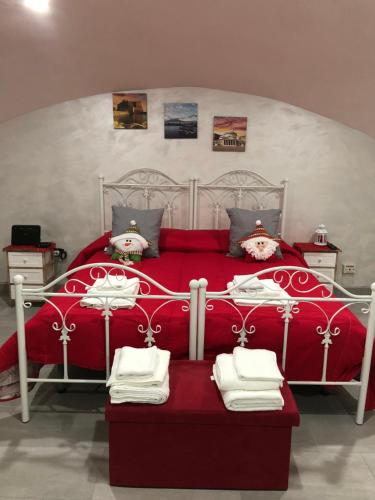 sypialnia z czerwonym łóżkiem i ręcznikami w obiekcie A'CASA E' MAMMA' w mieście Neapol