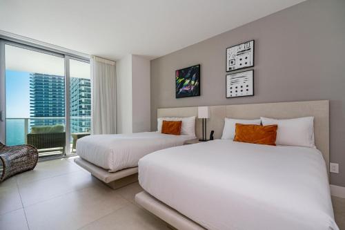 a bedroom with two beds and a large window at Amazing views on the 29th floor 2BR Beach Resort in Hallandale Beach