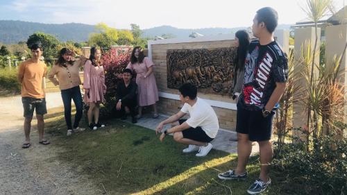 a group of people standing around a wall at Panutsaya Homestay in Wang Nam Khieo