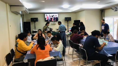a group of people sitting at tables in a room at Panutsaya Homestay in Wang Nam Khieo