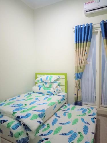 a bedroom with a bed with blue and green sheets at Alysahouse - 2 Bedrooms, Dekat JTP3 in Batu