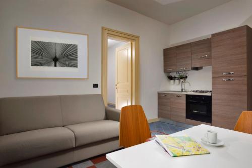 a living room with a couch and a kitchen at Roma Resort Termini in Rome