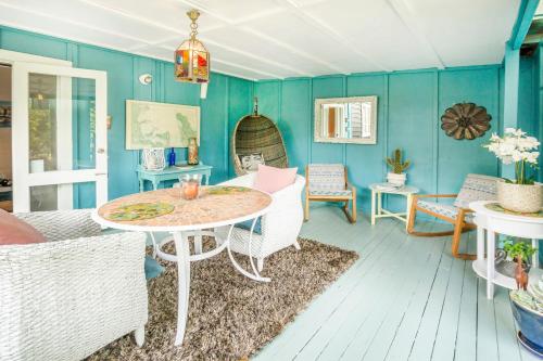 sala de estar con paredes azules, mesa y sillas en Annies B and B, en Warkworth