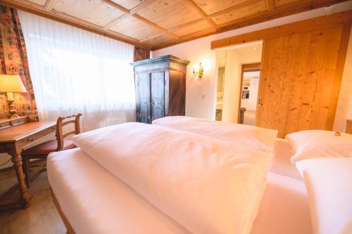 a bedroom with two beds and a table and a window at Haus Barbarahof in Altenmarkt im Pongau