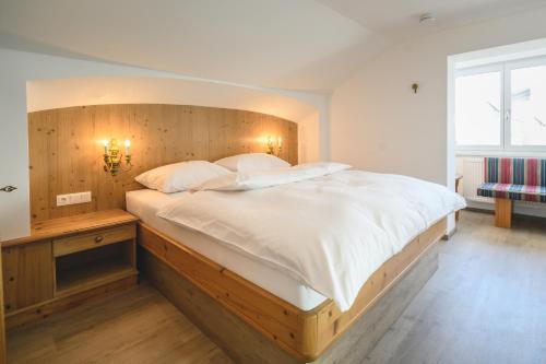 a bedroom with a large bed with a wooden headboard at Haus Barbarahof in Altenmarkt im Pongau